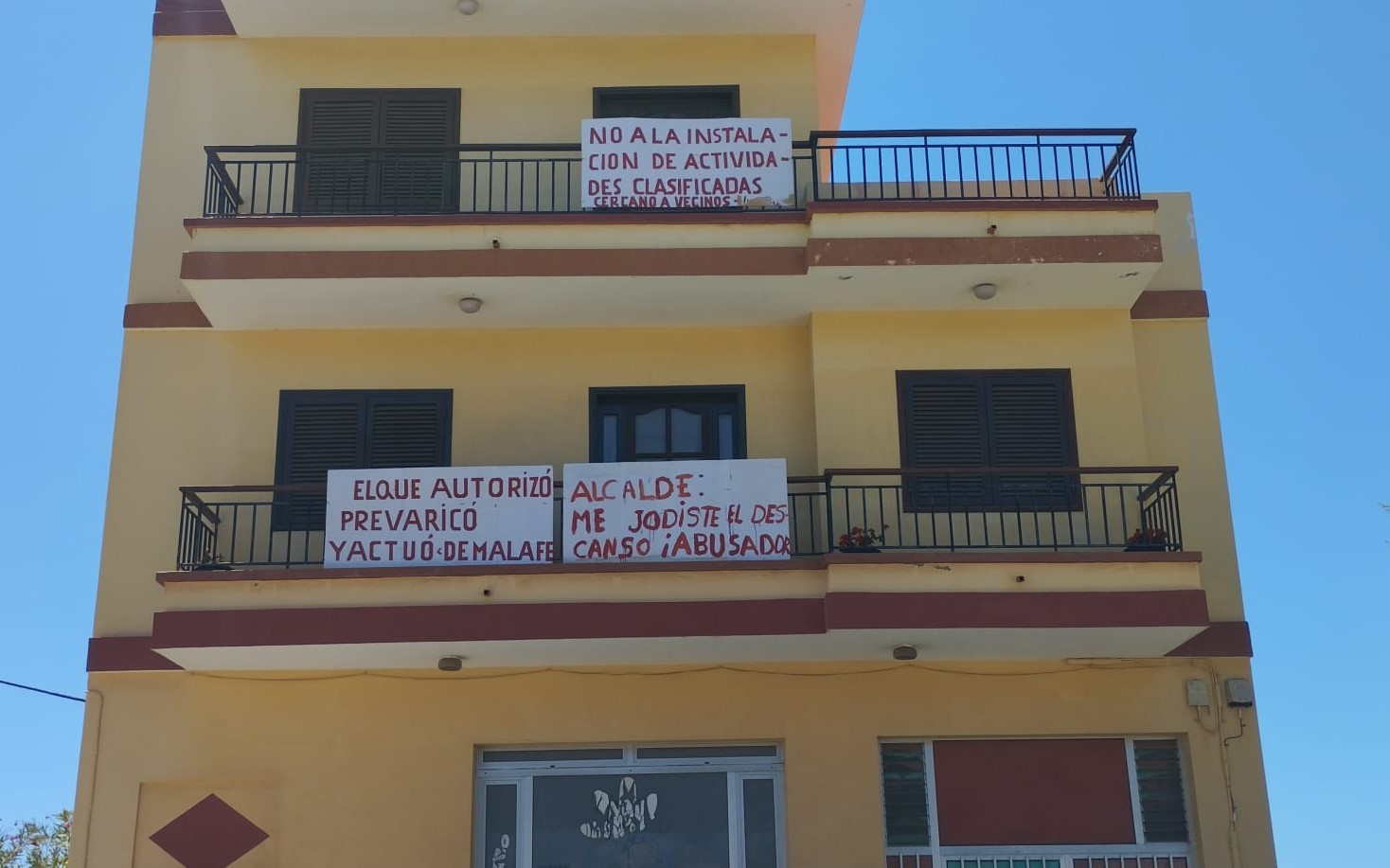 Pancartas de protesta en el edificio situado enfrente de la terraza.