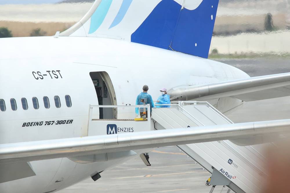Viajeros de nacionalidad canadiense evacuados del crucero MV Hondius suben a un avión, en el aeropuerto de Tenerife Sur.